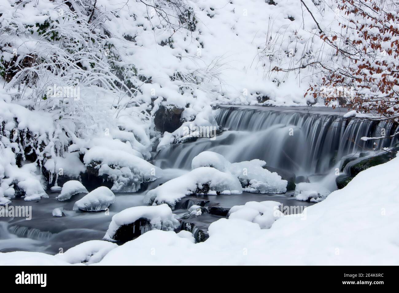 Schnee und Fluss mit Wasserfall. Frostiger Winter Stockfoto