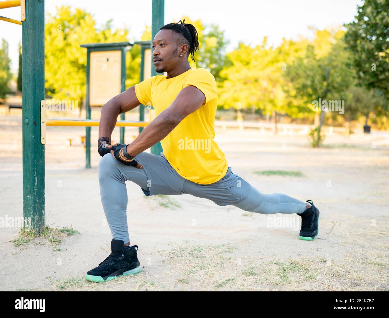Sportler, der sich beim Training im Park Bein streckt Stockfoto