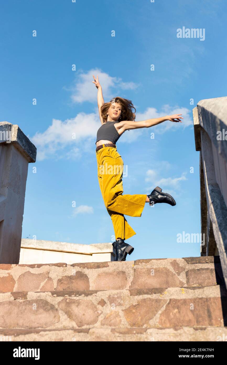 Junge Frau tanzt auf Steintreppen Stockfoto