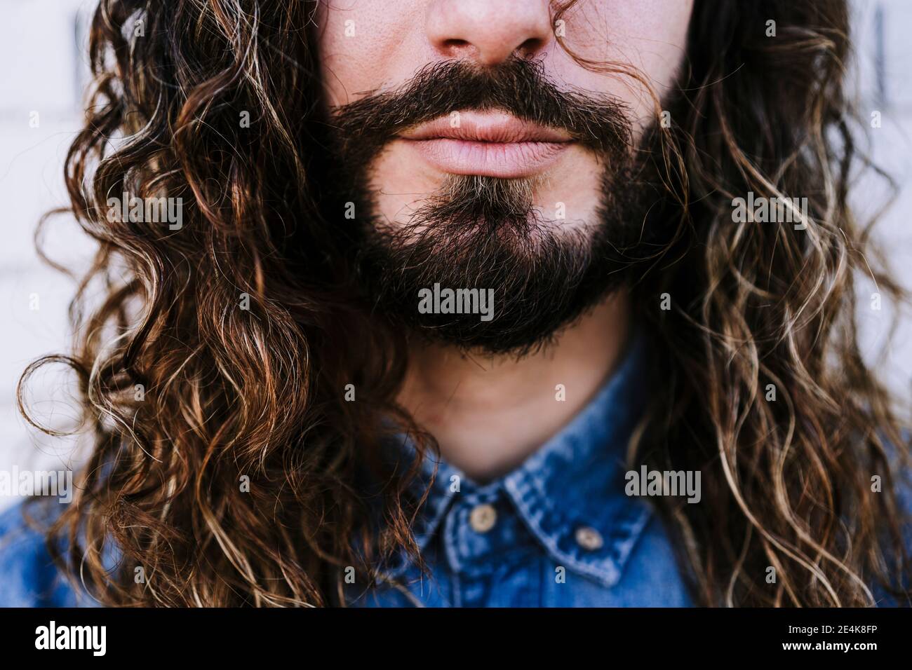 Junger Mann mit Bart und langen braunen Haaren Stockfoto