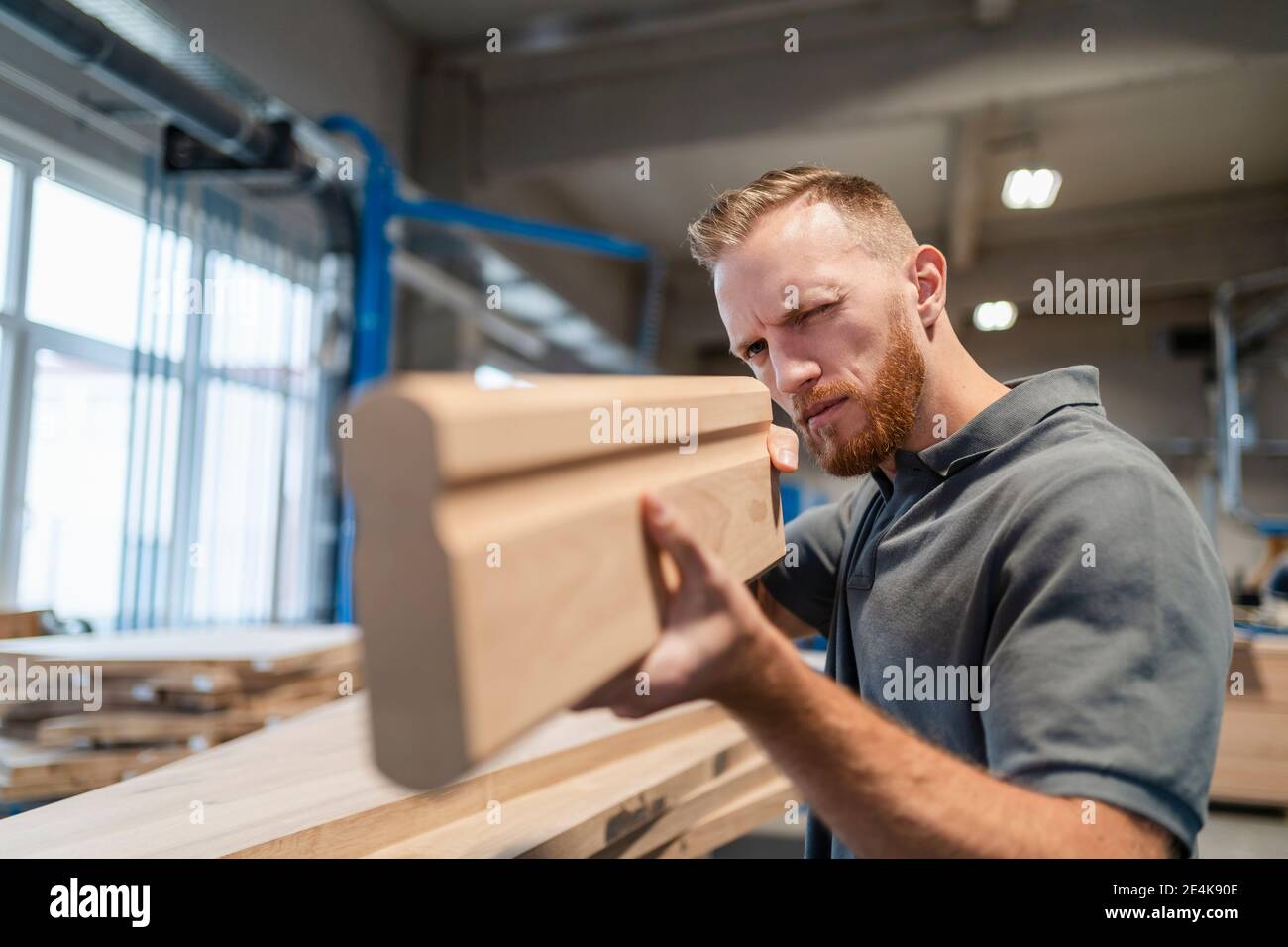 Portrait des Zimmermanns, der die Holzdiele untersucht Stockfoto