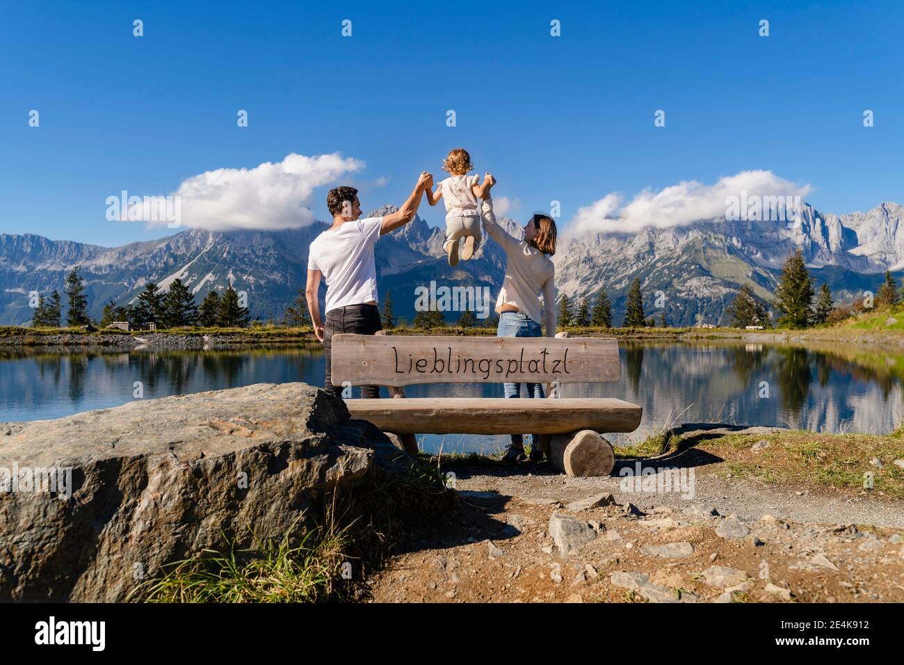 Familie mit einer kleinen Tochter, die zusammen hinter der Seeuferbank steht Im Kaisergebirge Stockfoto