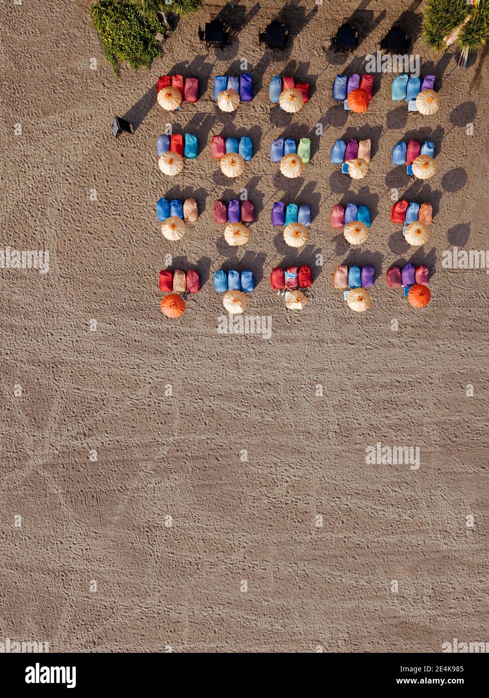 Luftaufnahme von Reihen von Sonnenschirmen und Liegestühlen am leeren Kuta Beach, Bali, Indonesien Stockfoto