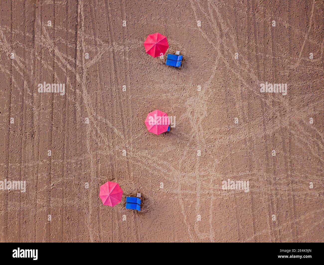 Luftaufnahme von Reihen von Sonnenschirmen und Liegestühlen am leeren Kuta Beach, Bali, Indonesien Stockfoto