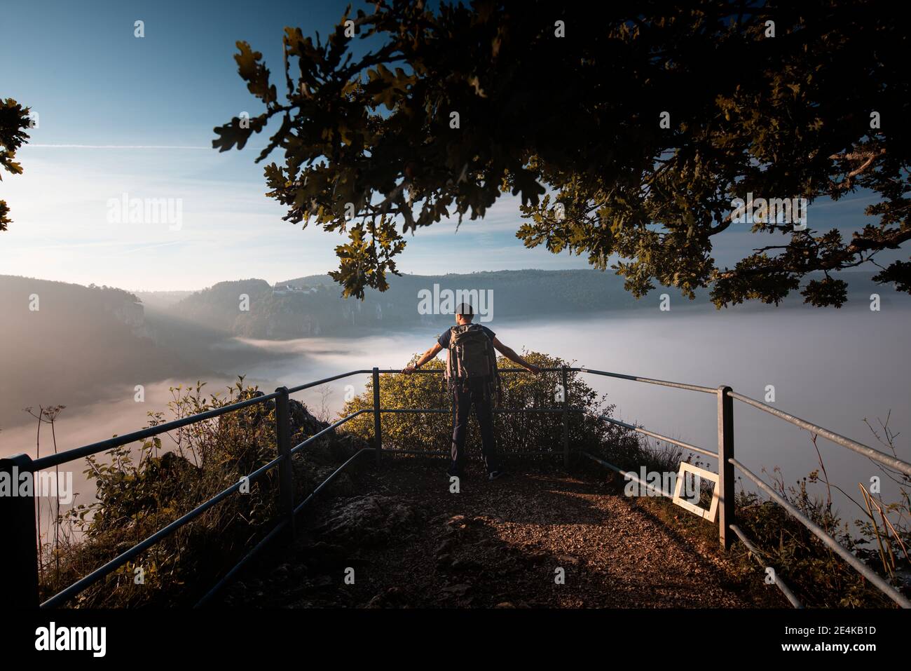 Männlicher Entdecker mit Rucksack, bewundernde Aussicht auf das Donautal bei Beuron, Schwäbische Alb, Deutschland Stockfoto