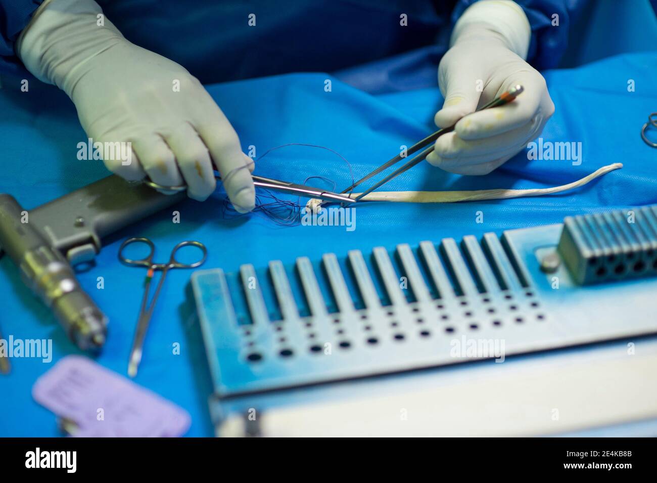 Reifer männlicher Chirurg, der medizinische Geräte auf der Intensivstation im Krankenhaus vorbereitet Stockfoto