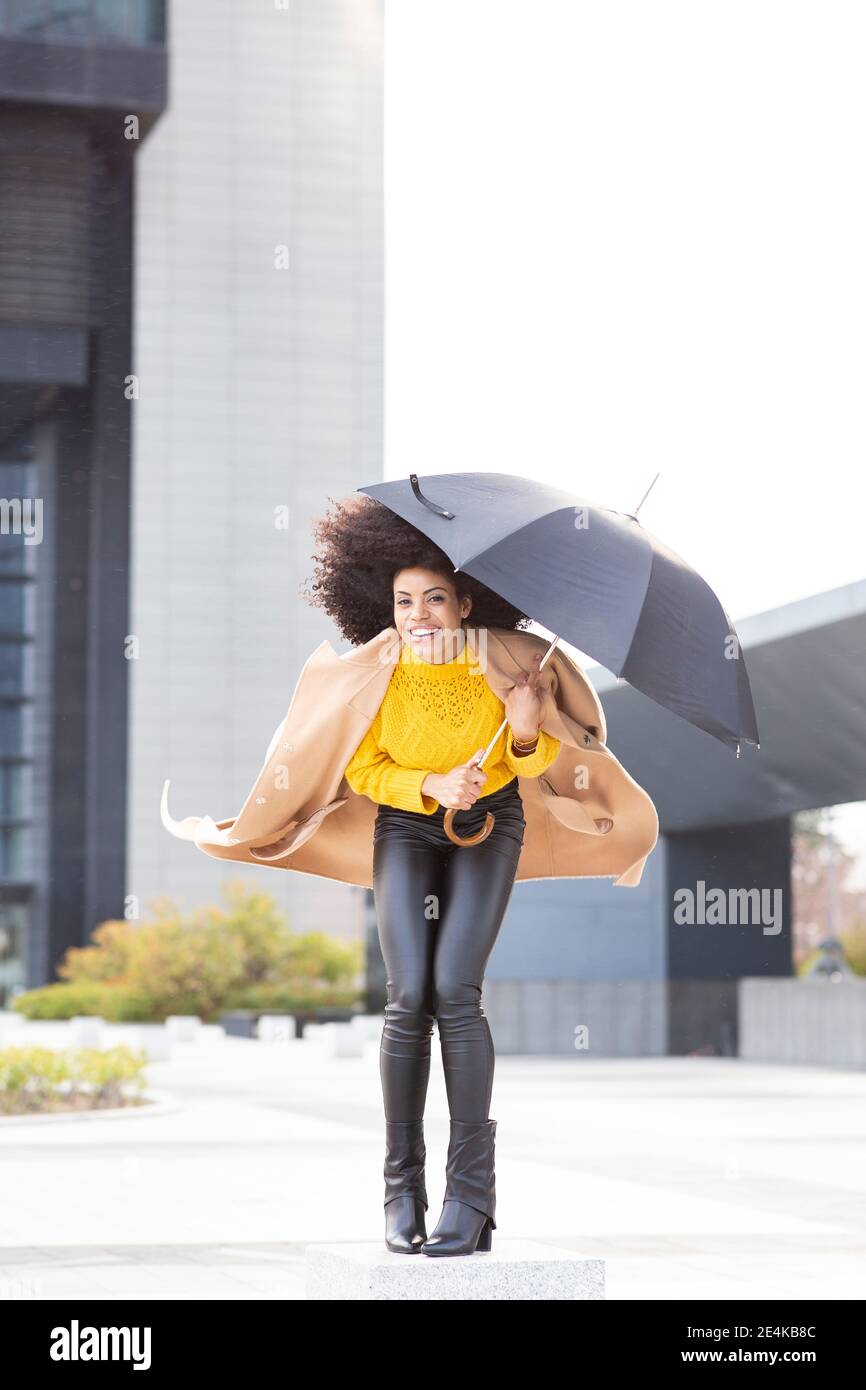 Fröhliche Frau, die Kamera hält, während sie im Fußpfad steht Stockfoto