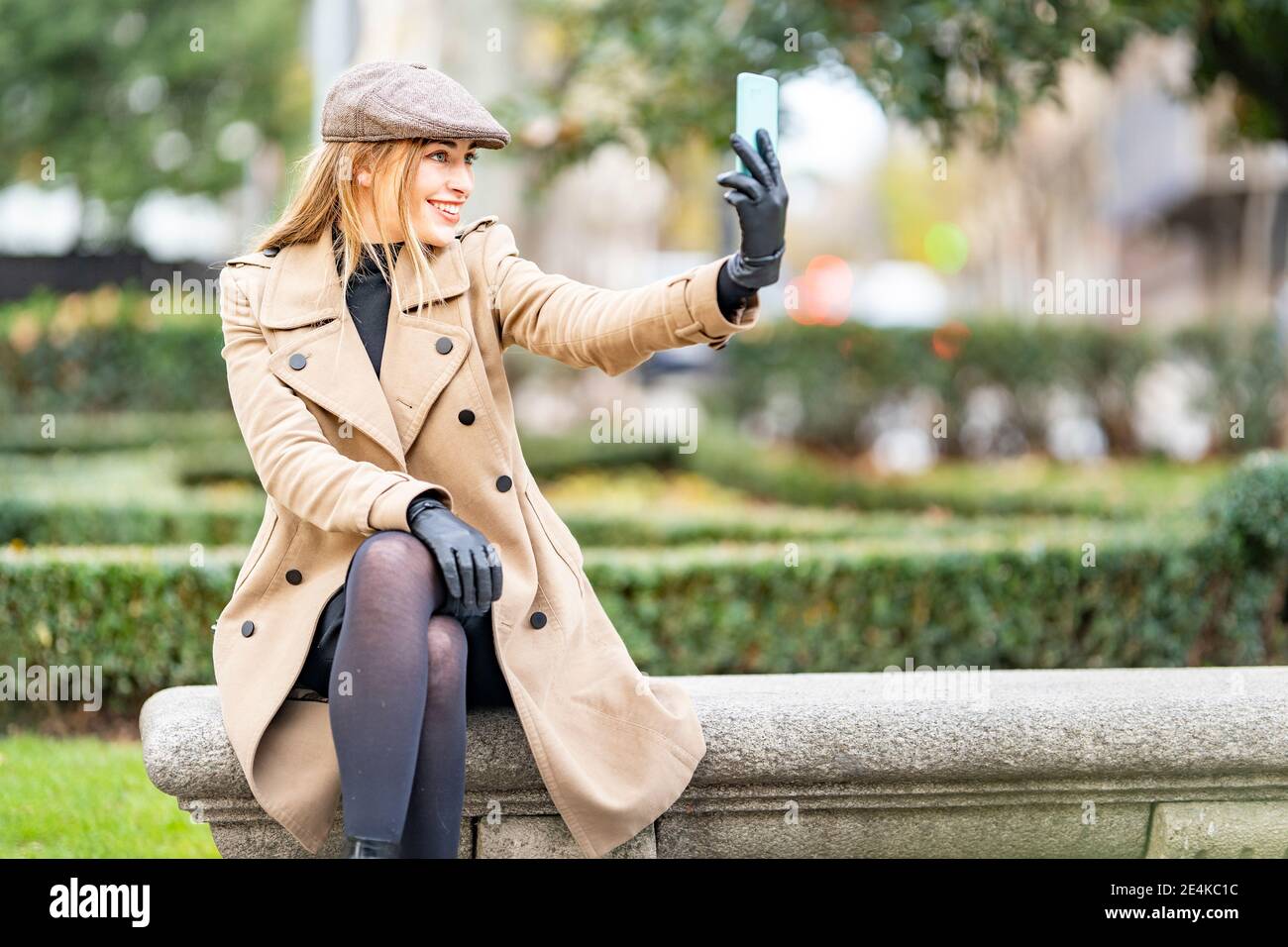 Attraktive Frau nimmt Selfie auf Handy im Park Stockfoto