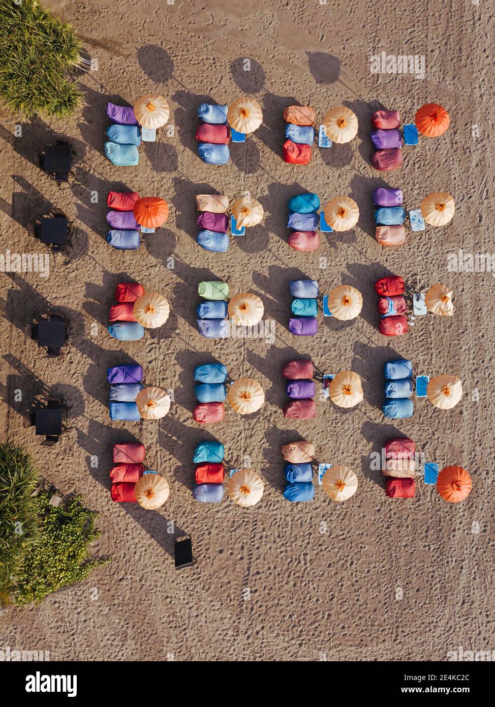 Luftaufnahme von Reihen von Sonnenschirmen und Liegestühlen am leeren Kuta Beach, Bali, Indonesien Stockfoto
