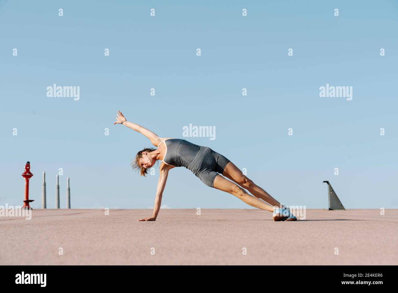 Weibliche Sportsperson üben Yoga Balancing auf einer Seite Stockfoto