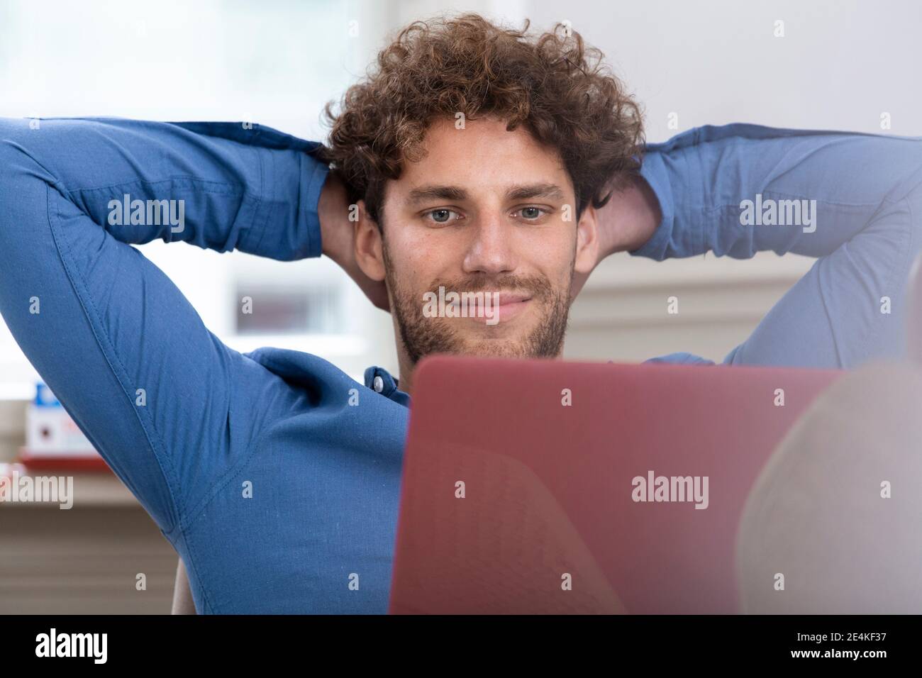 Männlicher Profi mit Händen hinter dem Kopf arbeiten im Büro Stockfoto Männlicher Profi mit Händen hinter dem Kopf arbeiten im Büro Stockfoto