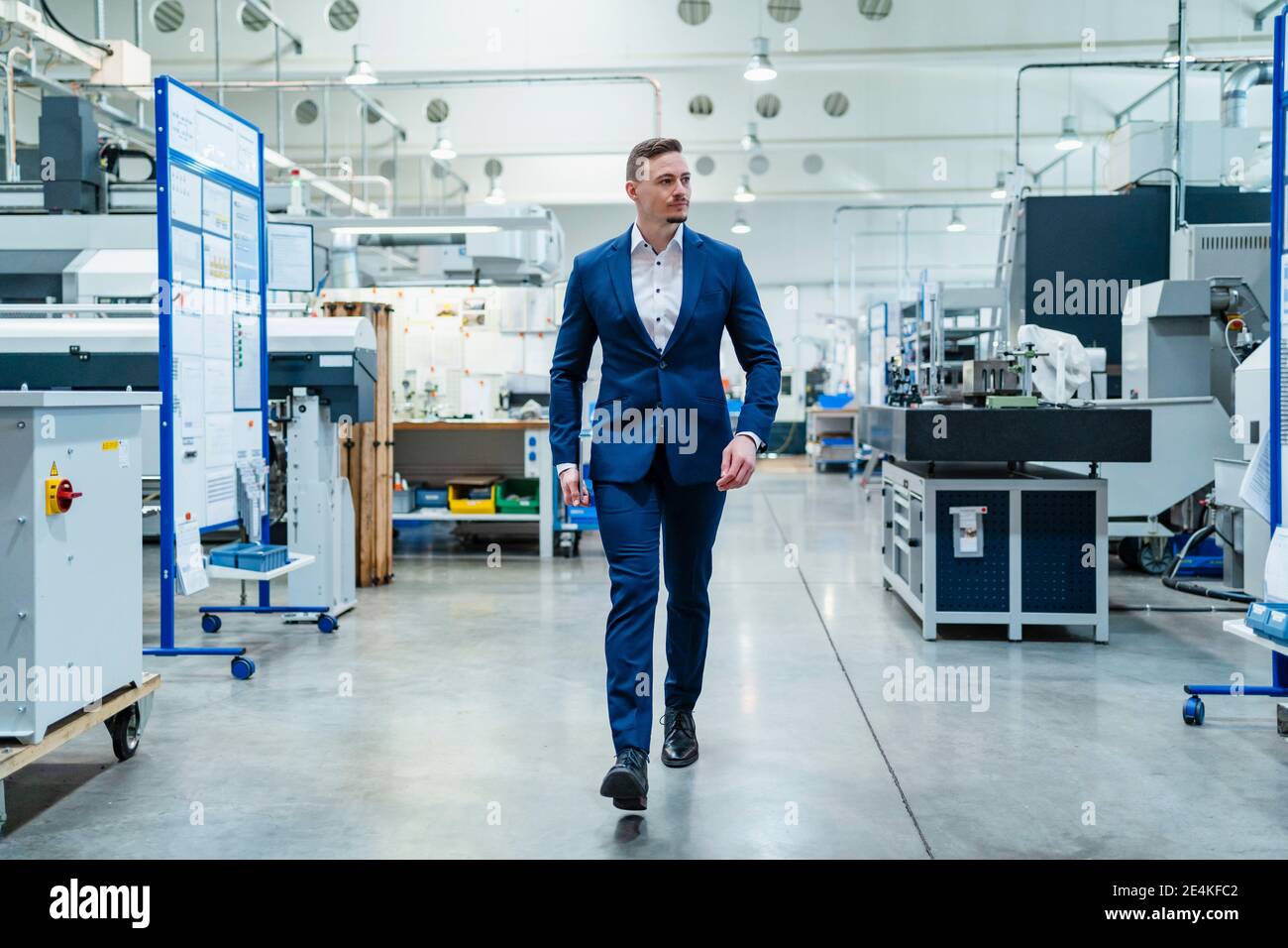 Männlicher Profi im Anzug zu Fuß in der Fabrik Stockfoto