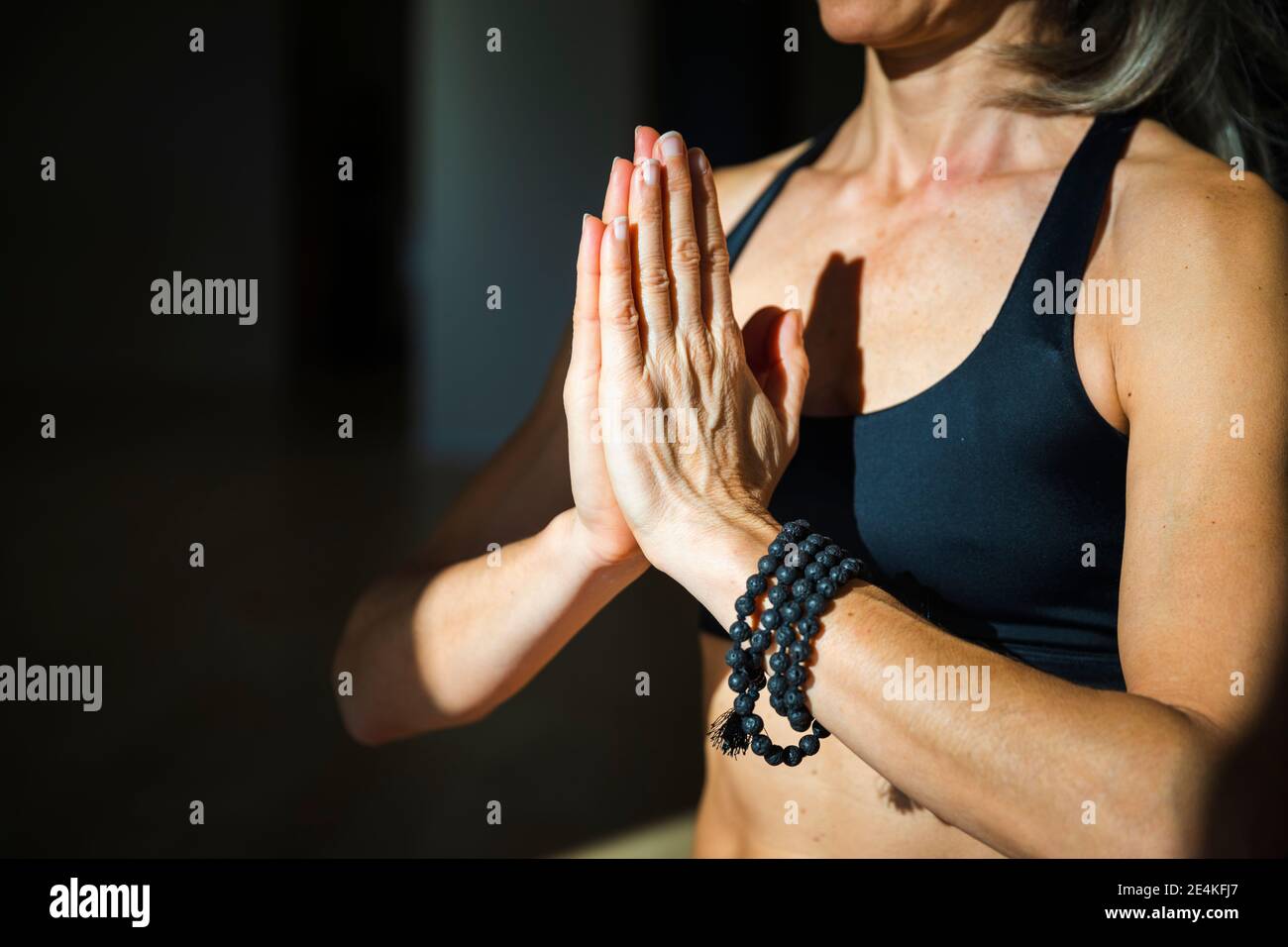 Yogini meditiert im Wohnzimmer an sonnigen Tagen Stockfoto
