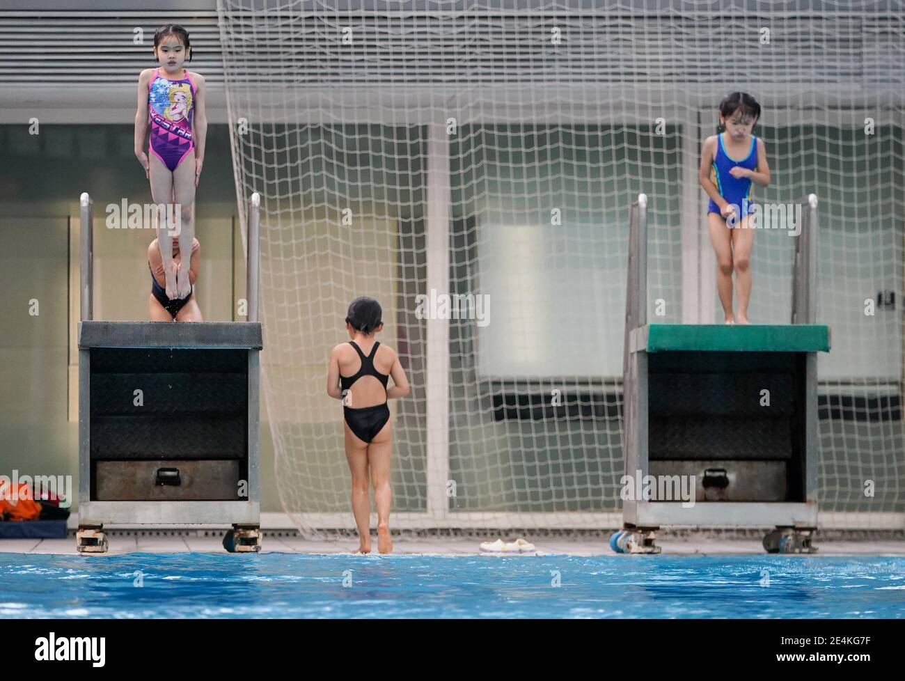 (210124) -- SHANGHAI, 24. Januar 2021 (Xinhua) -- Jiang Qiaochu (L, TOP) nimmt an einem Tauchtrainingsprogramm an der Shanghai Yangpu District Junior Sports School im ostchinesischen Shanghai Teil, 19. Januar 2021. Die fünfjährige Taucherin Jiang Qiaochu hat gerade im letzten Monat ihr Tauchtraining in der Shanghai Yangpu District Junior Sports School begonnen. Manchmal hat sie noch Angst und zögerte einige Minuten, bevor sie einen Sprung von einer fünf Meter hohen Plattform machte. Aber sie lässt die Angst nie über sie kommen. Jiang ist eines der Kinder im Alter von 5 bis 7 Jahren an einem Tauchtrainingsprogramm in der Sportschule seit dem Sieg statt Stockfoto