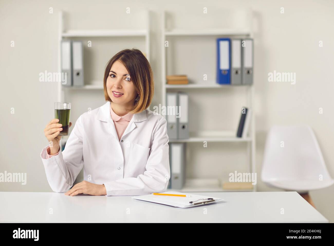Junge Frau Ernährungswissenschaftlerin hält Glas von grünem Chlorophyll Spirulina trinken Stockfoto
