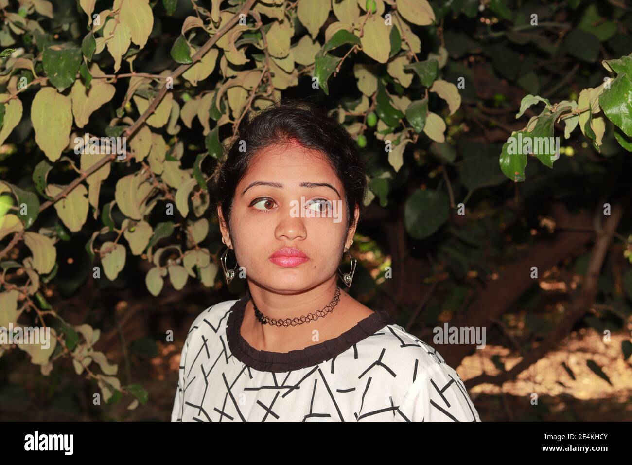 Fröhliche junge indische hindu Frau im Garten im Freien.Nahaufnahme Porträt von Junge hübsche hindu-Frau in weißem Top Stockfoto