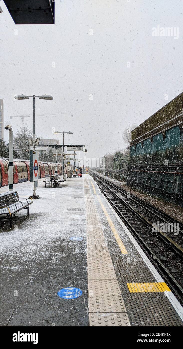 TFL-Arbeiter beeilte sich, während es am 24th. Januar 2021 schneit, auf dem Bahnsteig der Colindale U-Bahn-Station Spaltsalz zu verwenden. Der Transport nach London ist auf schlechtes Wetter im Londoner U-Bahnnetz nicht vorbereitet, obwohl die Wetterwarnungen von Met Office bei starkem Schneefall vorliegen. Colindale, London. Wetter in Großbritannien. Stockfoto