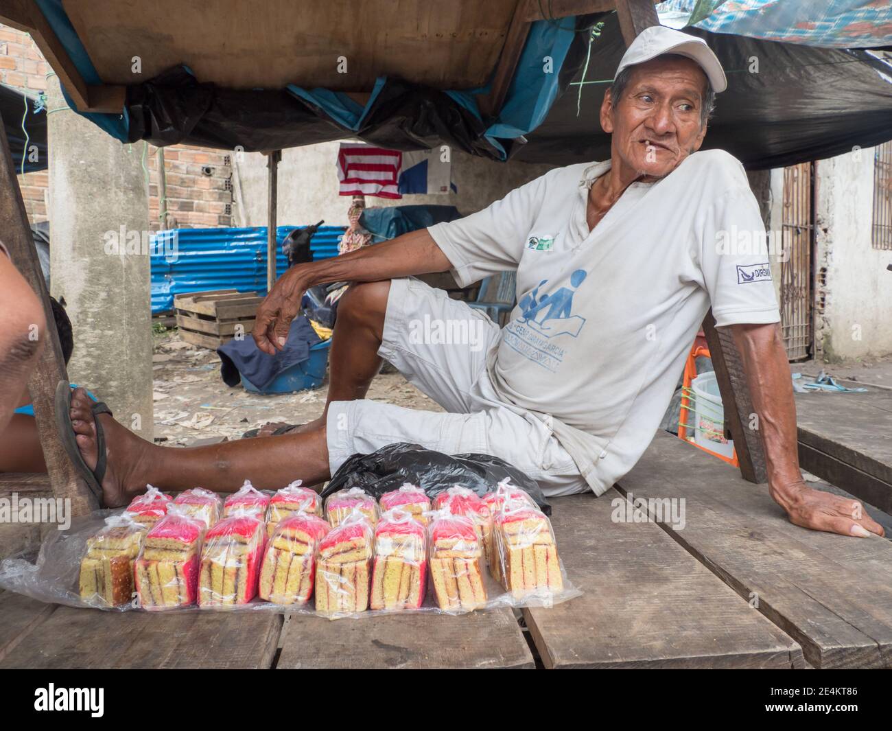 Iquitos, Peru - Dezember 2019: Porträt eines alten Mannes, der auf dem Tisch sitzt und Kuchen auf dem Belen Basar (Belén Markt) verkauft, Iquitos - Tor zum Stockfoto