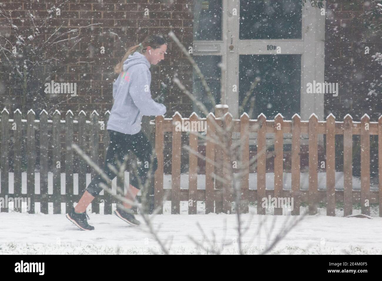 UK Weather, London, 24 January 2021: Ein seltener Schneefall erreichte die Hauptstadt am Sonntagmorgen und beschichtete Bäume und Dächer über 2 Stunden mit etwa 2cm Schnee. Eine Frau bekommt ihre tägliche Übung, indem sie trotz des Schnees läuft. Anna Watson/Alamy Live News Stockfoto