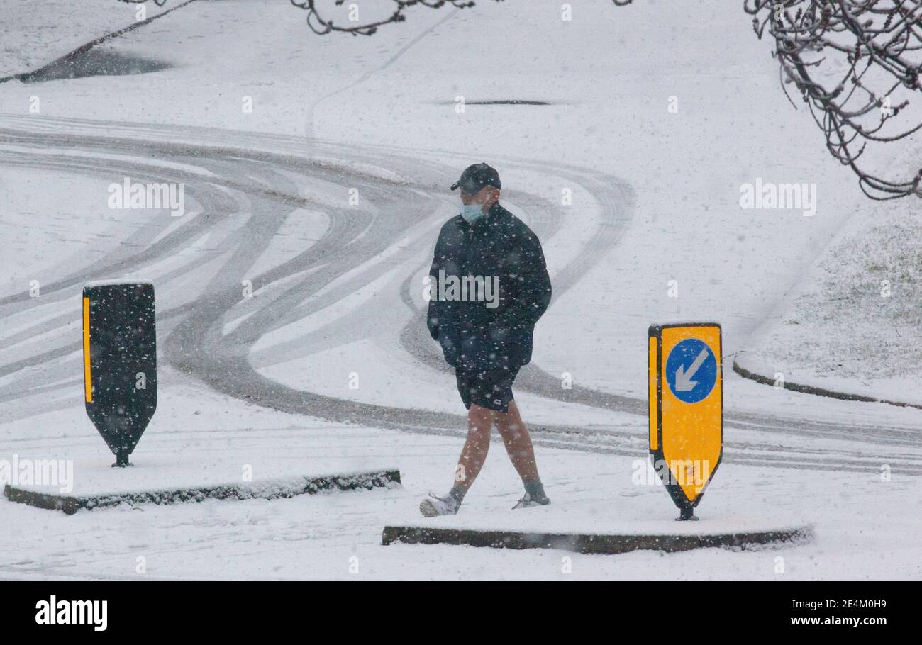 UK Weather, London, 24 January 2021: Ein seltener Schneefall erreichte die Hauptstadt am Sonntagmorgen und beschichtete Bäume und Dächer über 2 Stunden mit etwa 2cm Schnee. Ein Mad trägt Shorts trotz der kalten Termperatur. Anna Watson/Alamy Live News Stockfoto