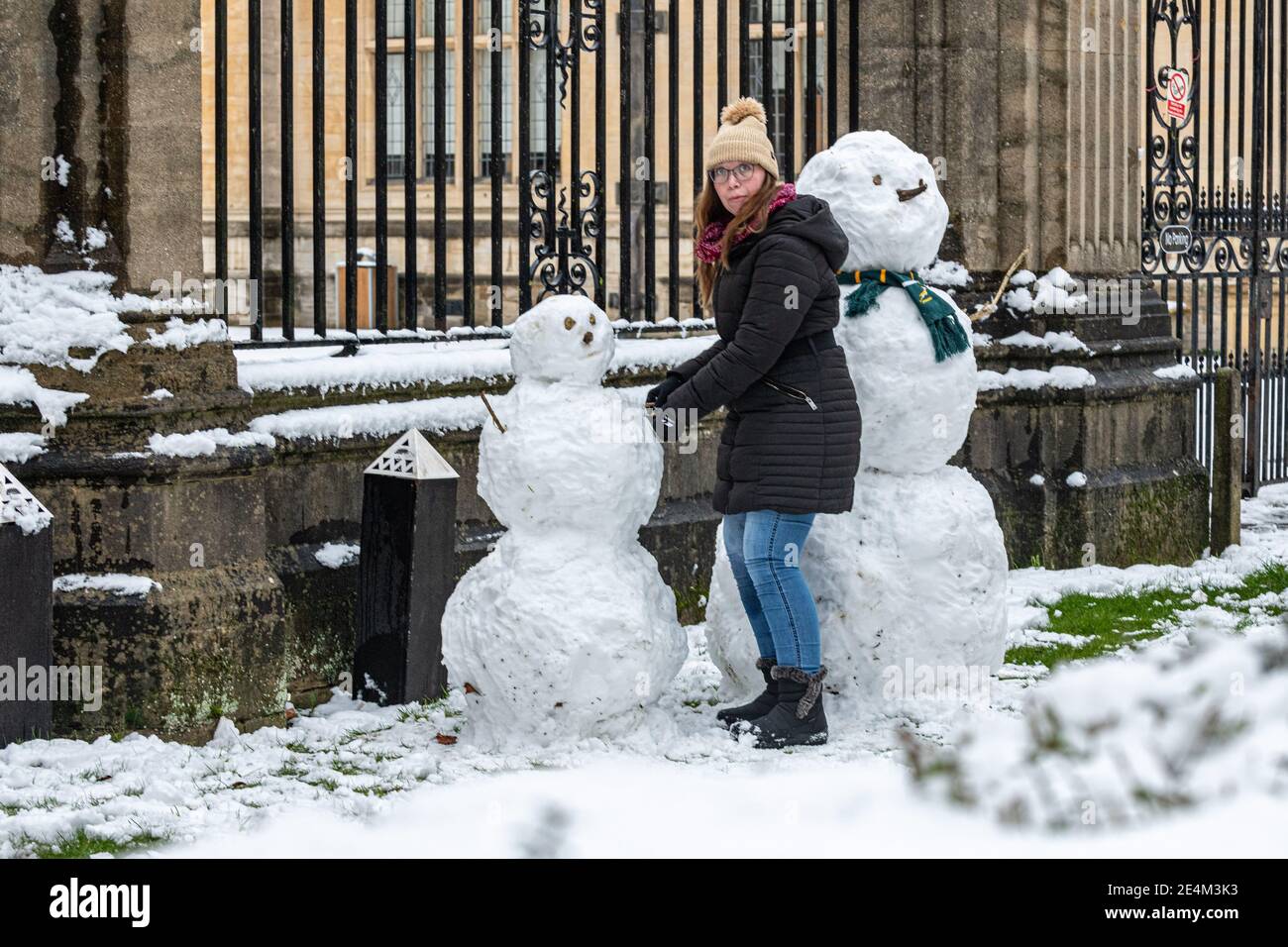 Oxford, Oxfordshire, Großbritannien. Januar 2021, 24. Ein Mädchen baut Schneemänner vor den Toren der Prüfungsschulen in der Merton Street. Mehrere Zentimeter Schnee fallen in Oxford. Das Stauben von Schnee über die historischen Gebäude von Oxford zieht Massen trotz der Sperre an, Credit: Sidney Bruere/Alamy Live News Stockfoto