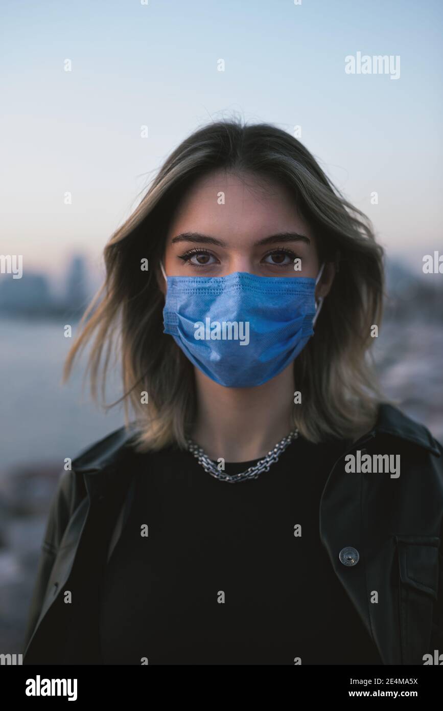 Porträt eines Teenagers Mädchen mit einer medizinischen Gesichtsmaske auf der Straße. Stockfoto
