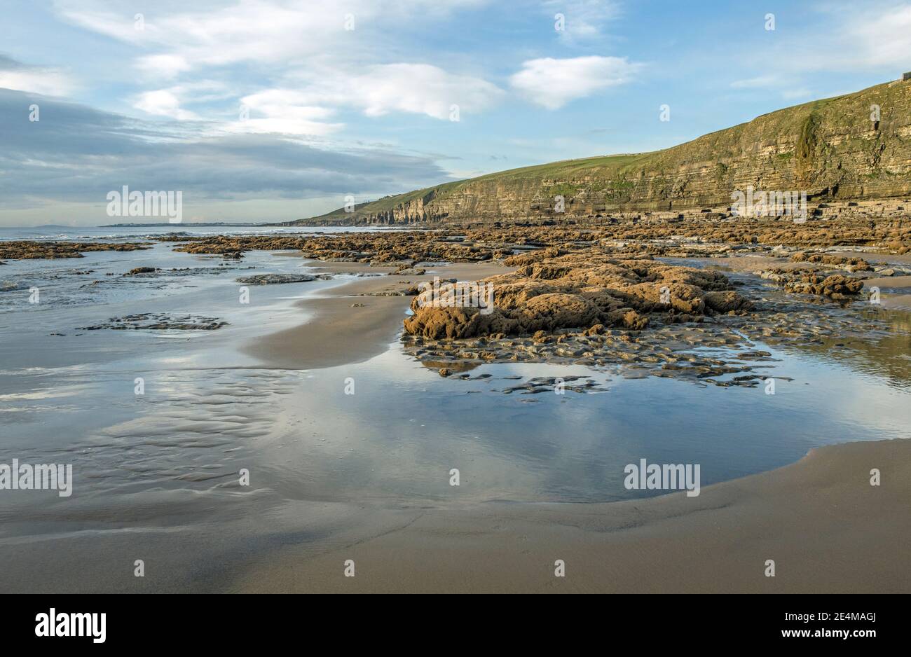 Dunraven Bay Blick nach Westen über Pools, feuchten Sand und Felsen und Klippen an der Glamorgan Heritage Coast, Vale of Glamorgan, South Wales Stockfoto