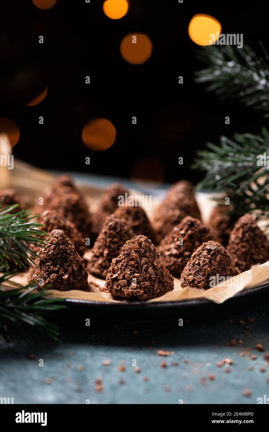 Trüffelschokolade-Bonbons mit verschiedenen Waffelbröseln. Süßes hausgemachtes Dessert auf einem Teller Stockfoto