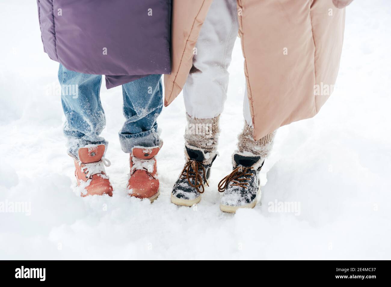 Zwei Paar Beine in stylischen Winterstiefeln. Stockfoto