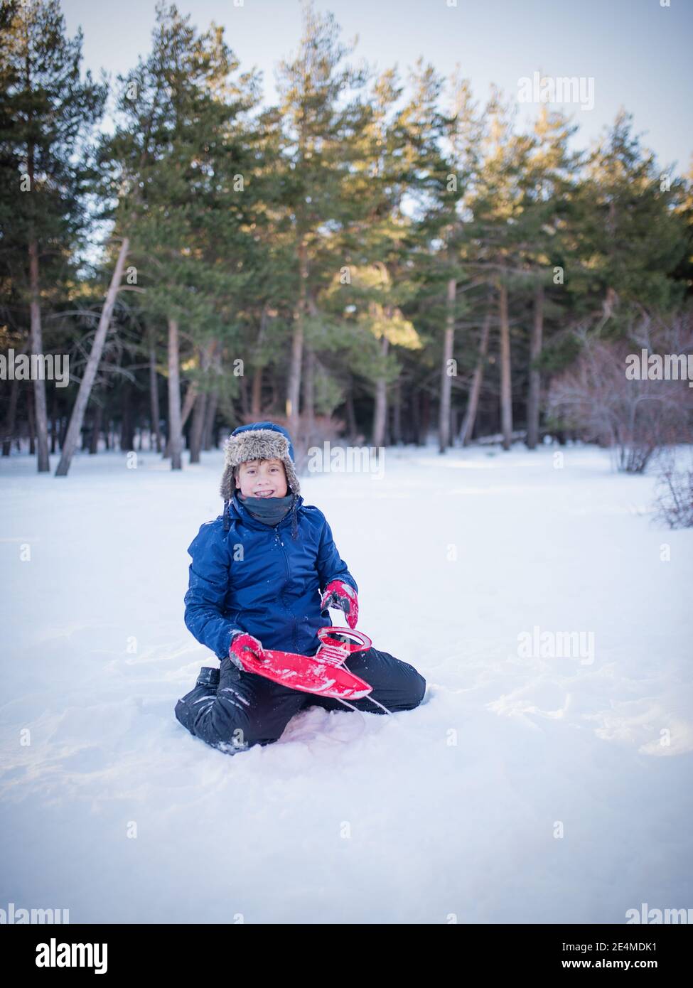 Lustiger Kerl, der im Schnee sitzt Stockfoto