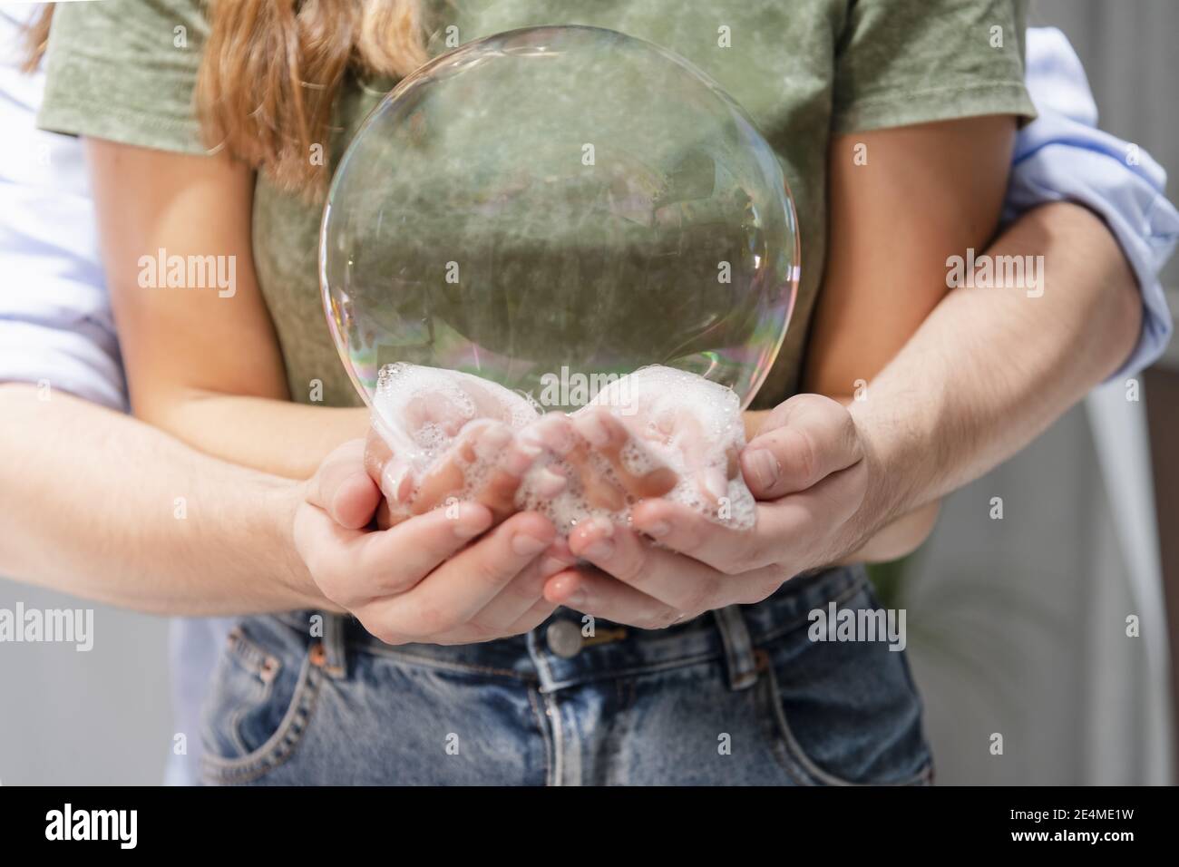 Eine selektive Fokusaufnahme einer großen Seifenblase auf Ein paar Hände Stockfoto