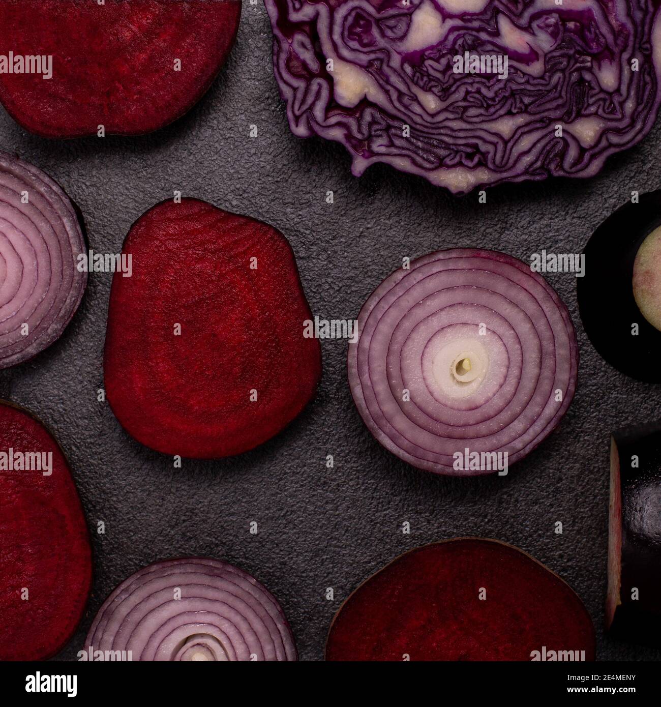 Quadratisches Muster aus violettem Gemüse, roter Zwiebel, Kohl, Eierpflanze und Rübenwurzel. Flach lag auf schwarzem Hintergrund Stockfoto