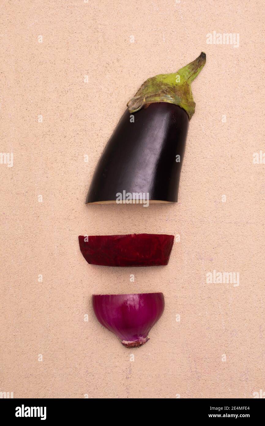 Eierpflanze, rote Zwiebel und Rübenwurzel auf dem Tisch geschnitten, Gemüse Stockfoto