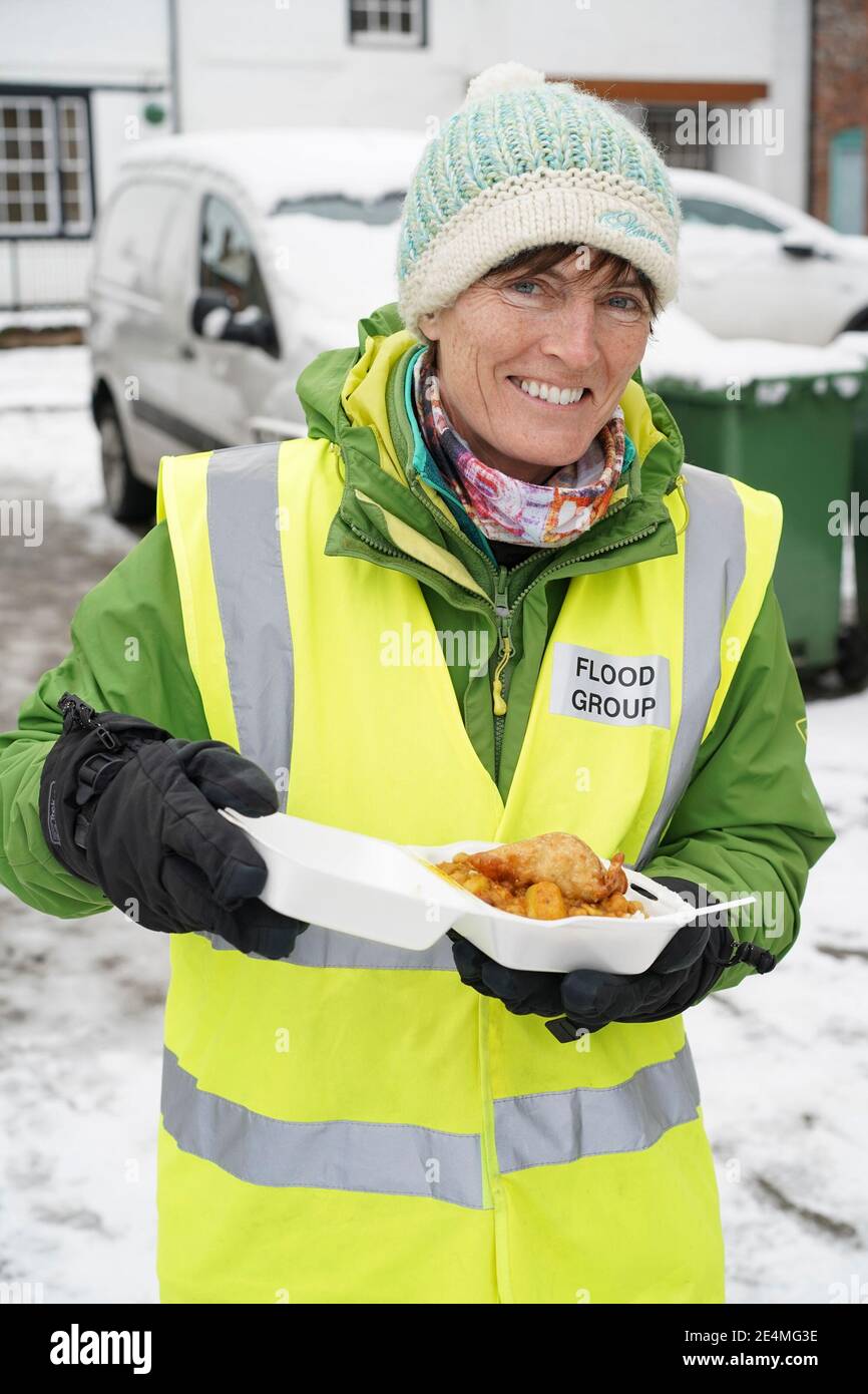 Bewdley, Großbritannien. Januar 2021. Alle Hände sind heute an Deck und helfen bei der Säuberung in Bewdley von Überschwemmungsschäden. Dieser Dame aus der örtlichen Hochwassergruppe wurde kostenloses warmes Essen angeboten, das den Bedürftigen serviert wird und aushilft. Gekocht und serviert von Khalsa Aid (Khalsa Aid International ist eine humanitäre Hilfsorganisation in Großbritannien, die Opfer von Naturkatastrophen und von Menschen verursachten Katastrophen unterstützt), die außerhalb des öffentlichen Hauses des Black Boy eingerichtet werden. Stockfoto