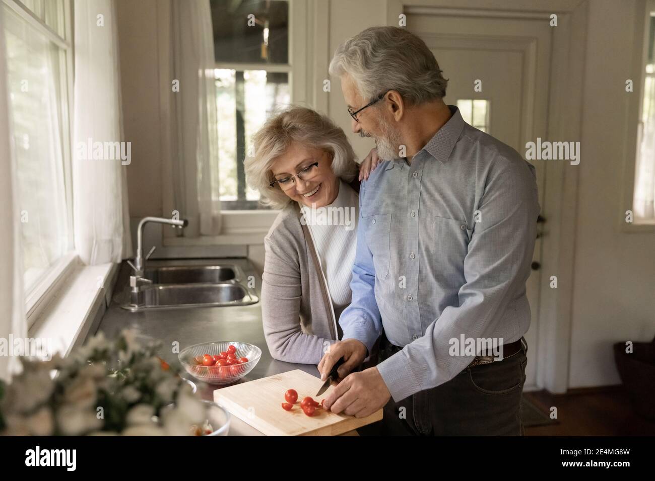 Glücklich reifen Mann und Frau Kochen Salat in der Küche zusammen Stockfoto