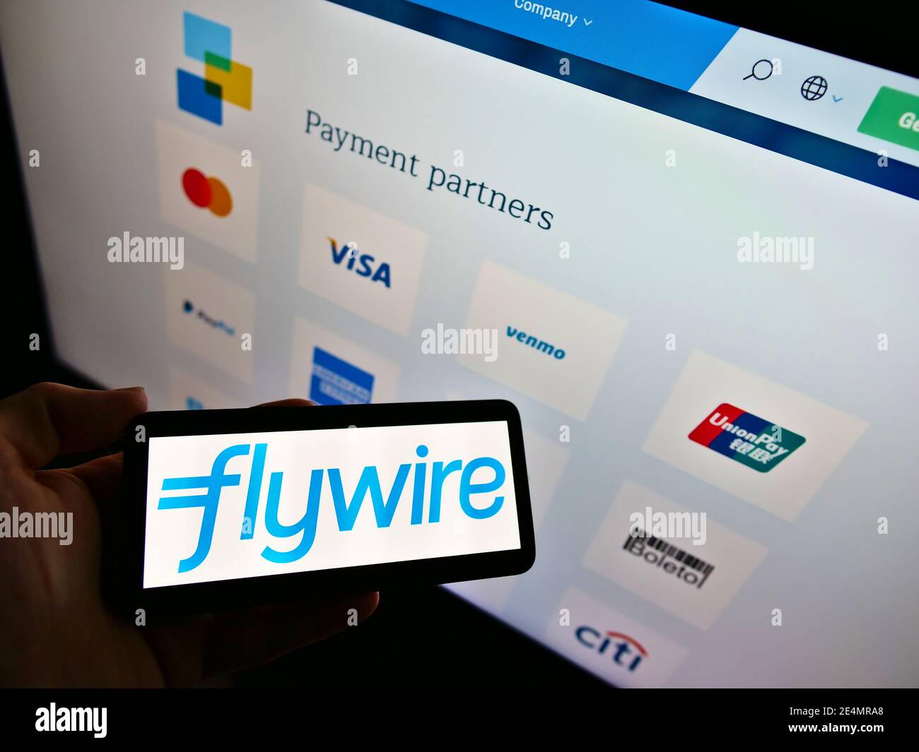 Person, die das Smartphone mit dem Logo des Zahlungsdienstleisters Flywire auf dem Bildschirm mit den Zahlungspartnern des Unternehmens hält. Fokus im Handy-Display. Stockfoto