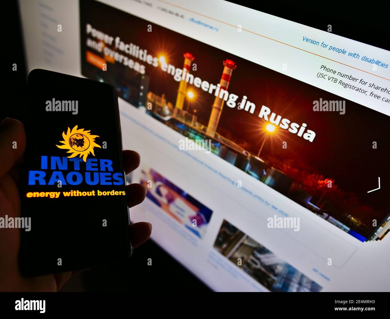 Person, die Smartphone mit Logo der russischen Elektrizitätsgesellschaft Inter Rao auf dem Display hält. Konzentrieren Sie sich auf die Mitte des Smartphone-Bildschirms. Stockfoto