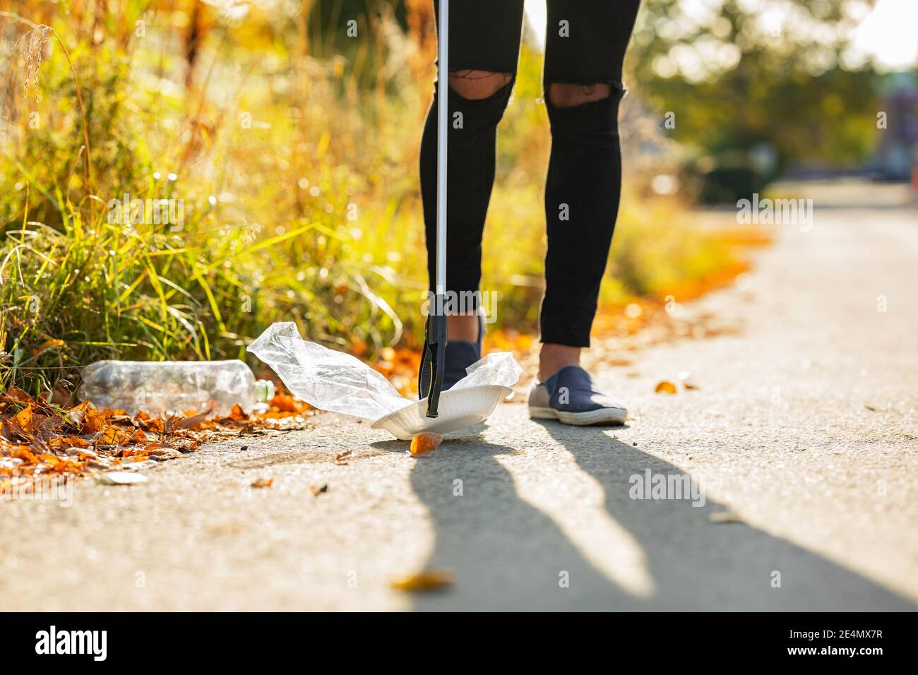 Männer nehmen freiwillig Kunststoff aus Gras auf Stockfoto