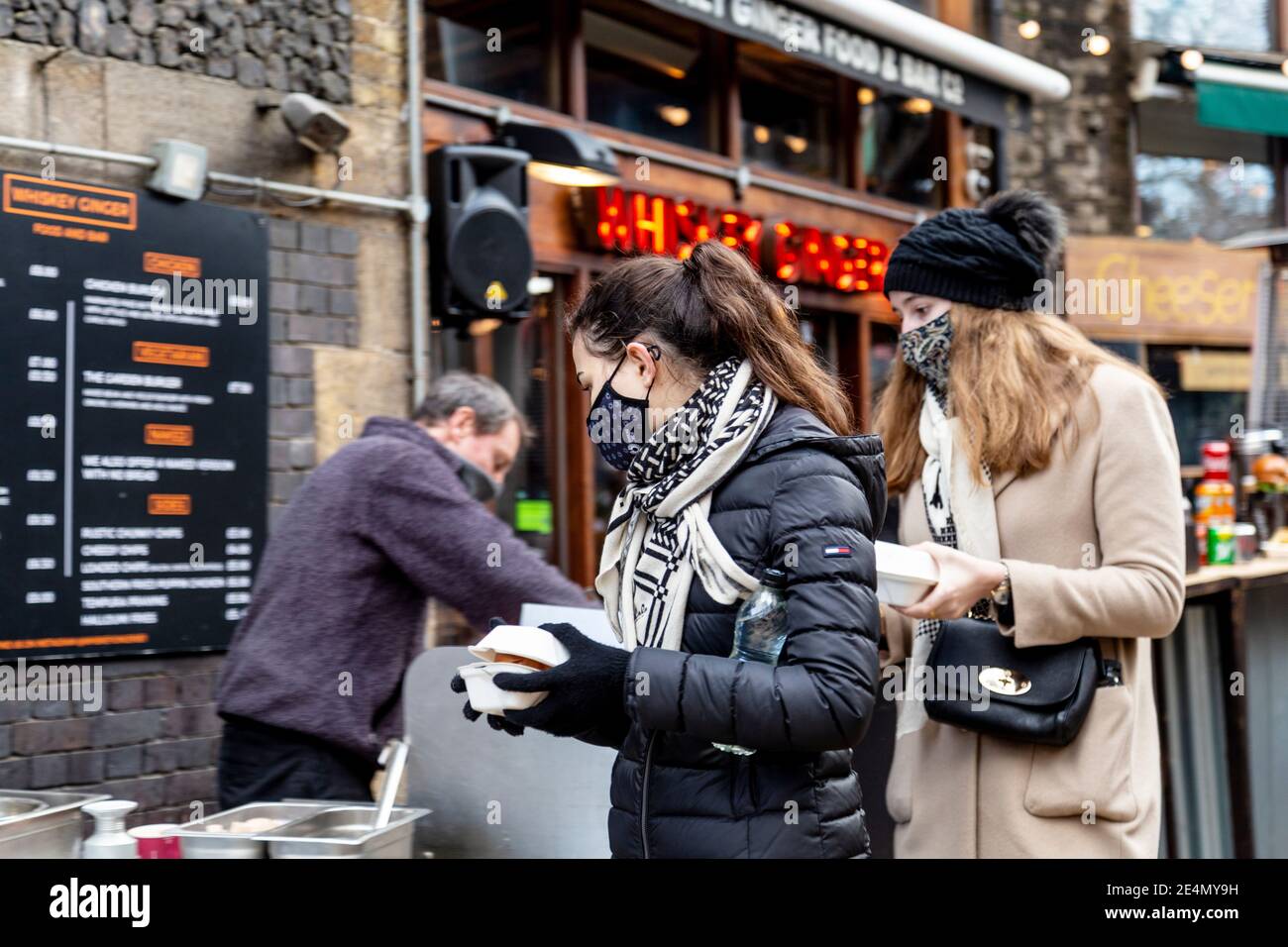 23. Januar 2021 - London, Großbritannien, geschäftiges Borough Market während der 3. Coronavirus-Sperre tragen Frauen Gesichtsmasken an einem Street-Food-Stand Stockfoto