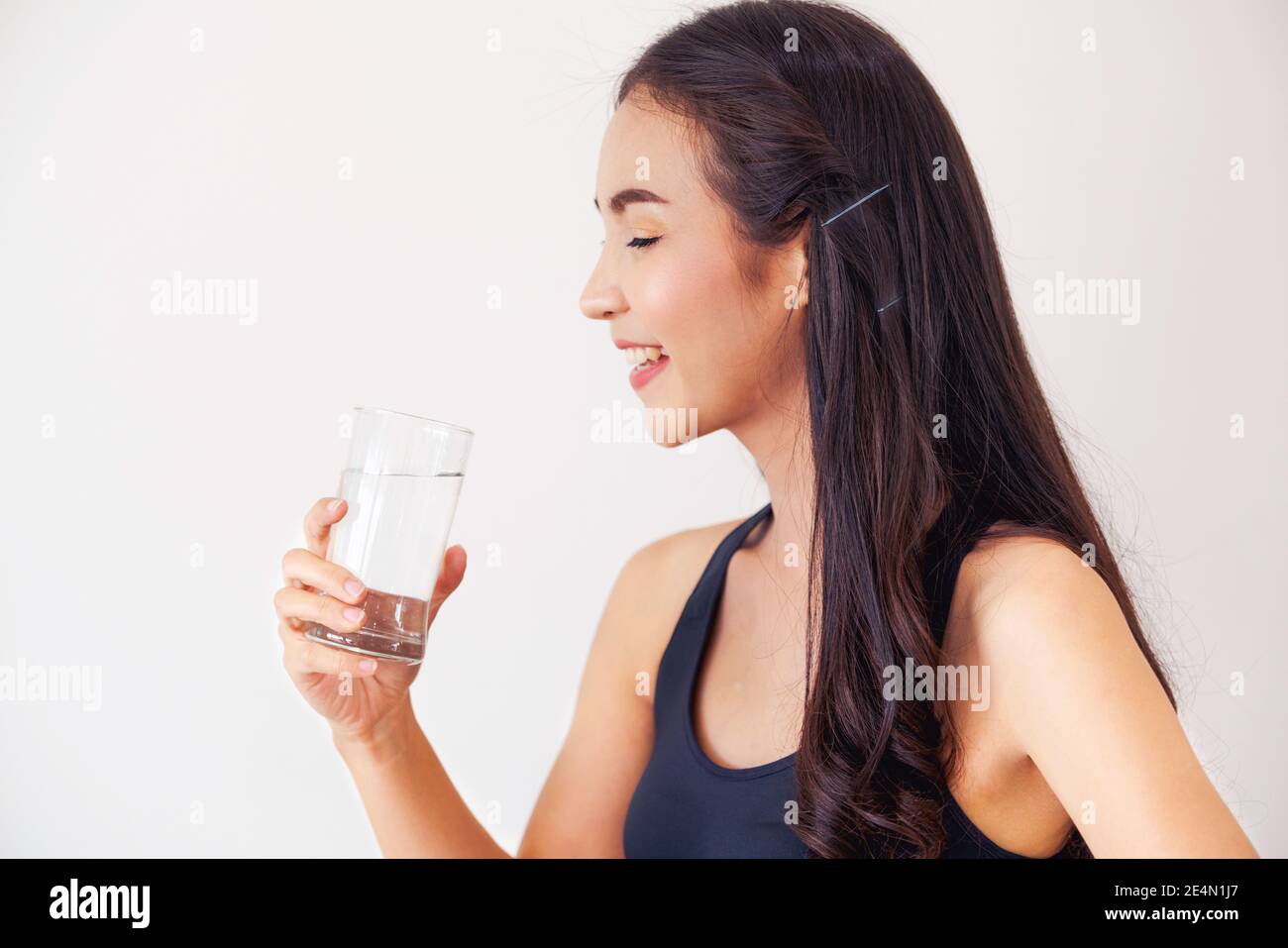 Frau in Sportswear Trinkwasser in einem Fitnessstudio. Gesunder Lebensstil und Hydratation Konzept. Stockfoto