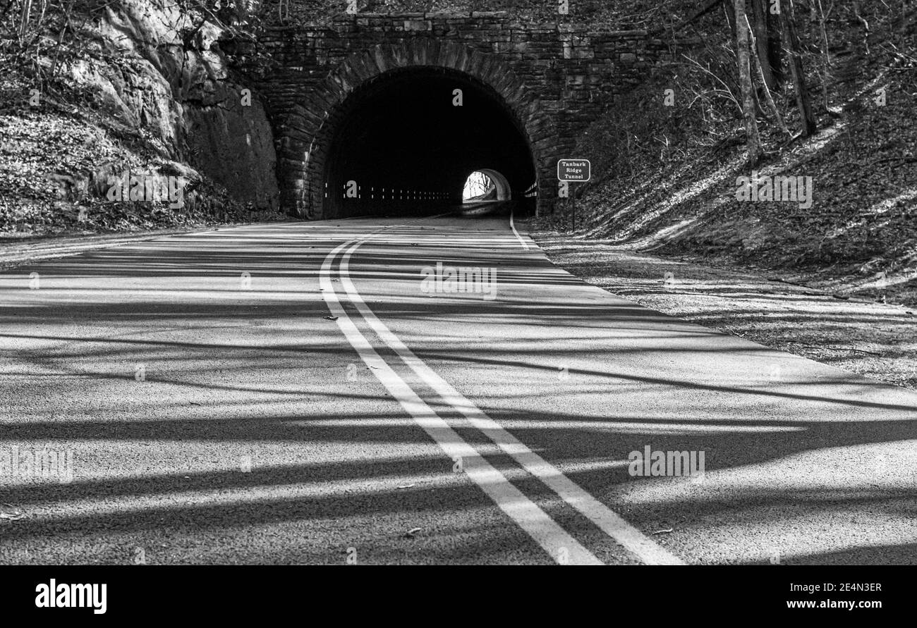 Straßenlinien führen in einen kreisförmigen Tunnel auf dem Blue Ridge Parway in der Nähe von Asheville, NC, USA Stockfoto