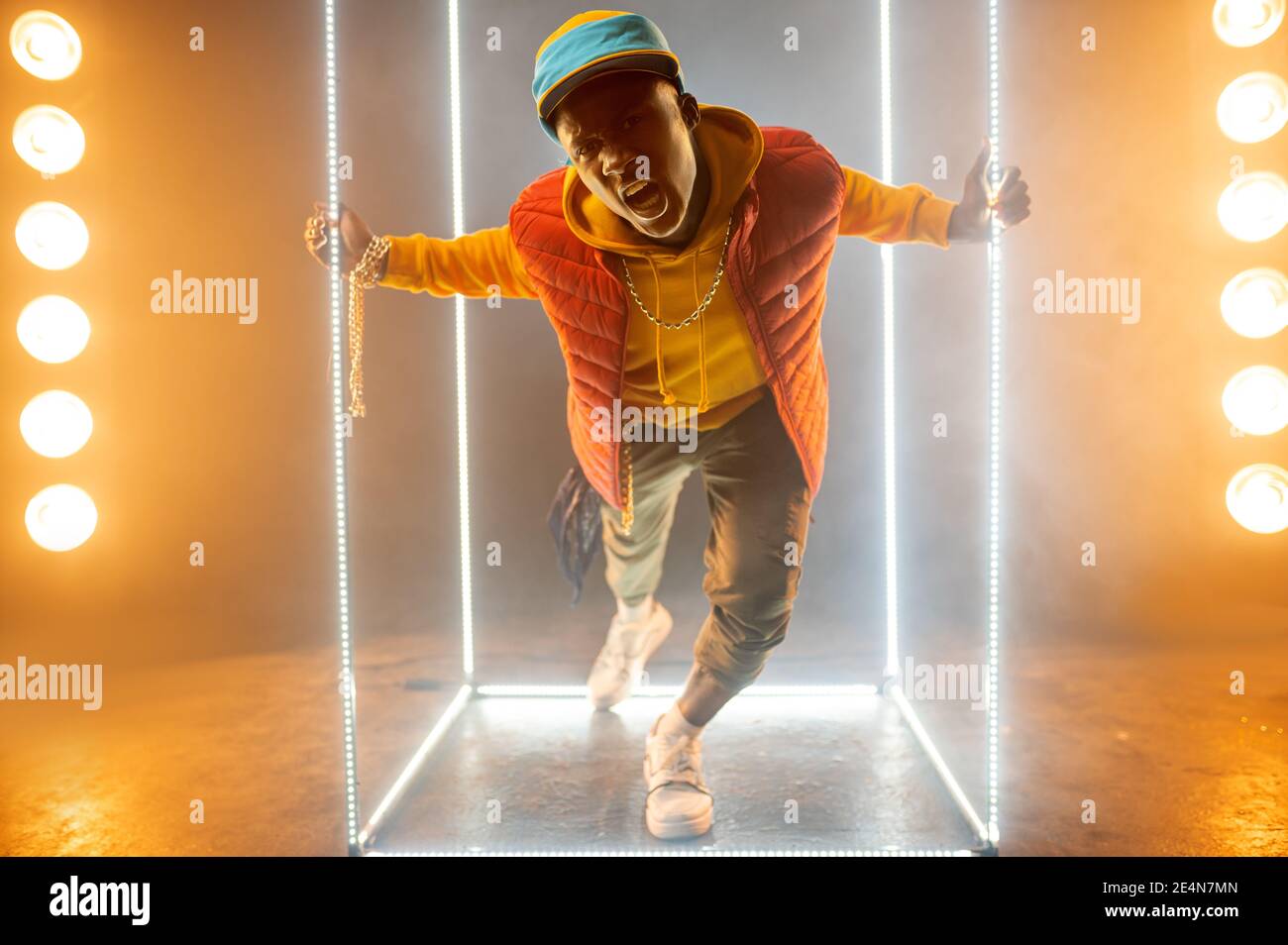 Stilvoller Rapper auf der Bühne mit beleuchtetem Würfel Stockfoto