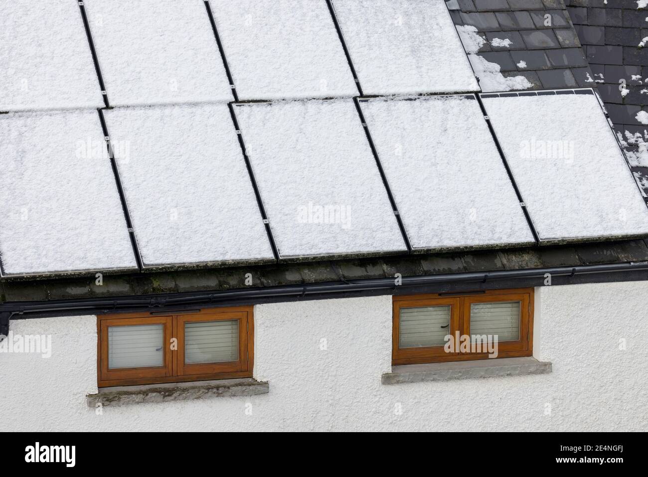 Sonnenkollektoren auf Hausdach mit Schnee bedeckt und nicht in der Lage, Strom zu erzeugen, Llanfoist, Wales, Großbritannien Stockfoto