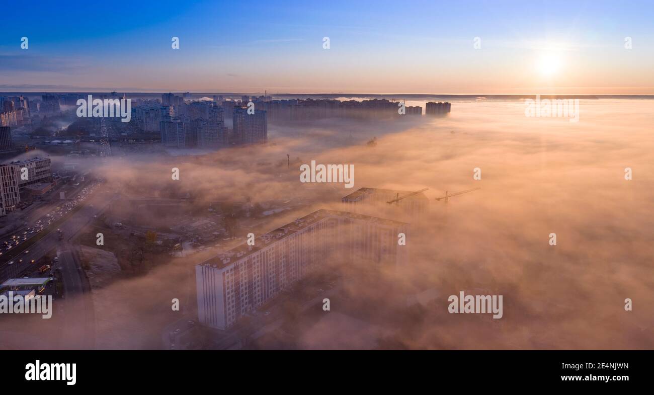 Die Gipfel der Hochhäuser über dem Nebel. Drohnenansicht. Stockfoto