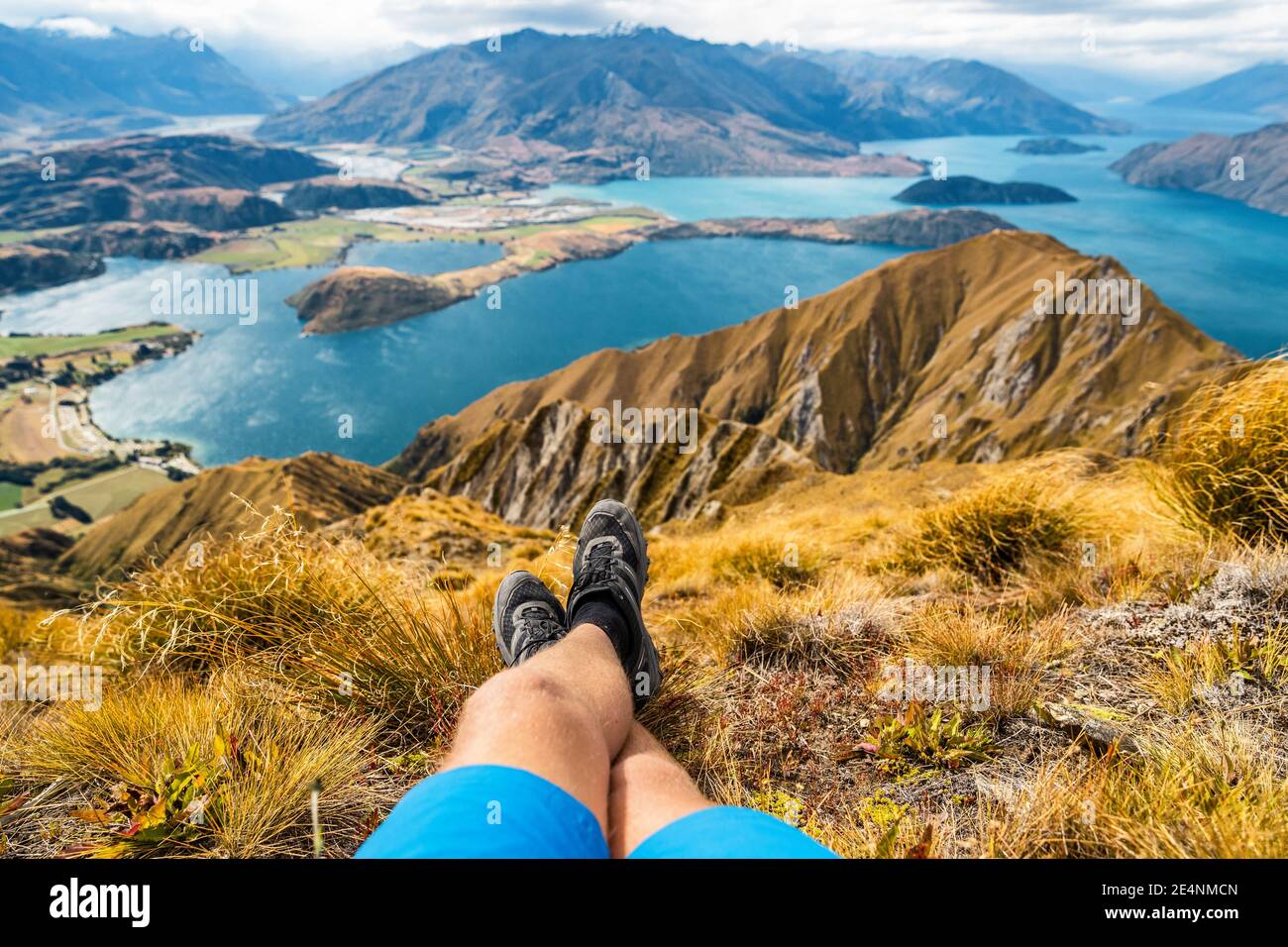 Abenteuer und Wandern Wanderlust Reise Urlaubskonzept mit Wanderschuhen aus nächster Nähe. Wanderer, der die Aussicht von der berühmten Wanderung zum Roys Peak auf betrachtet Stockfoto