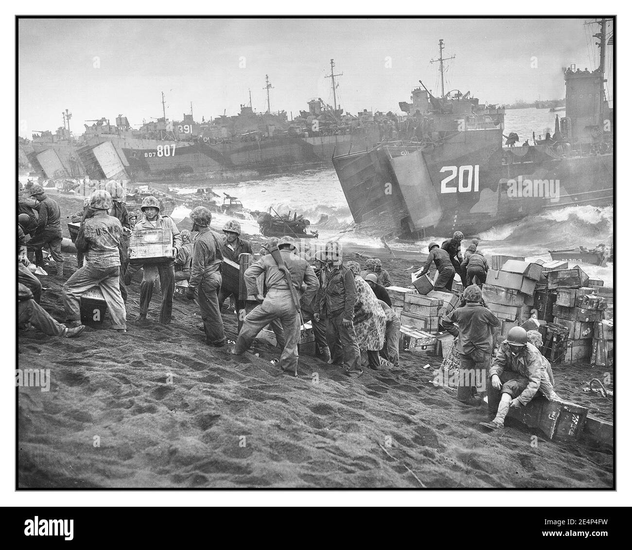WW2 Iwo Jima Supply Beachhead World war II: Iwo Jima U.S. Coast Guard und US Navy Schiffe landen auf dem Marine Beachhead in Iwo Jima, Japan der Meeresnebel, der einer sehr realen Landung eine filmische Qualität verleiht Februar 1945. Zweiter Weltkrieg Stockfoto