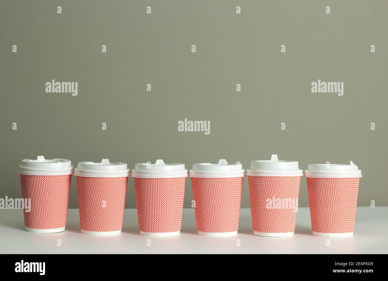 Reihe oder Reihe von Kaffeetassen auf dem Schreibtisch mit Kopierplatz Hintergrund. Kaffee kommerzielle Vorlage Design. Machen Sie sich ein Modell zum Mitnehmen von Kaffee oder zum Mitnehmen Stockfoto