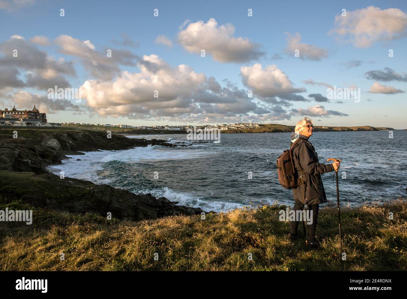 Frau beim Wandern auf dem Coast Path in der Nähe des Headland Hotels und der Towan Headland mit Blick auf den Fistral Beach in Newquay, Cornwall, England. Stockfoto