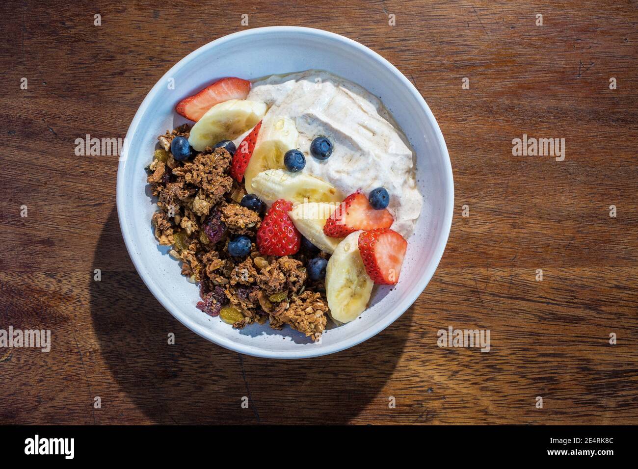 Müslischale mit frischem Obst und Joghurt auf dem Tisch im Café. Stockfoto