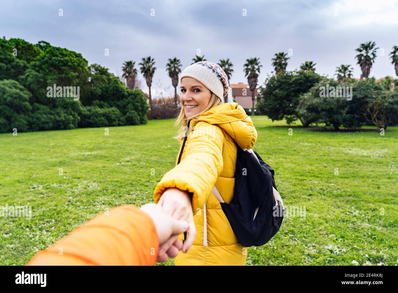 Frau, die Hände auf einem Hintergrund eines Parks hält Stockfoto